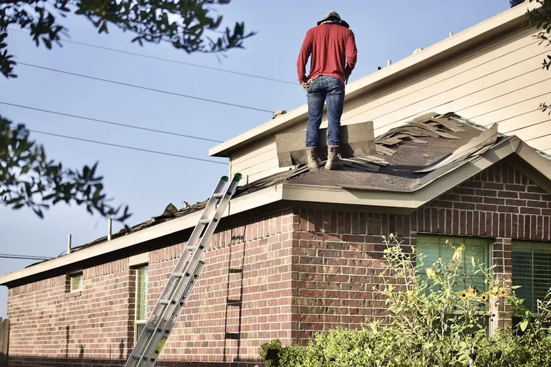 Professional roofer working on a residential roof in Whitneyville